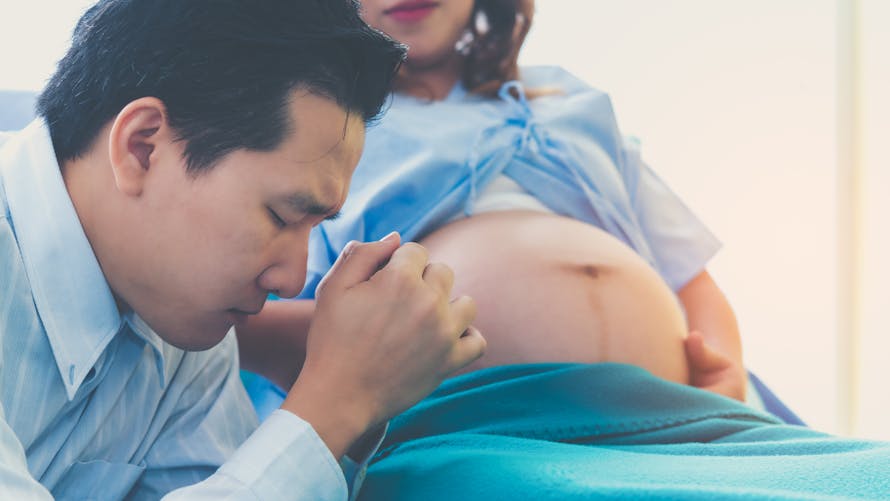 Le rôle du papa pendant l'accouchement : un papa qui tient la main de sa compagne lors de l'accouchement. 