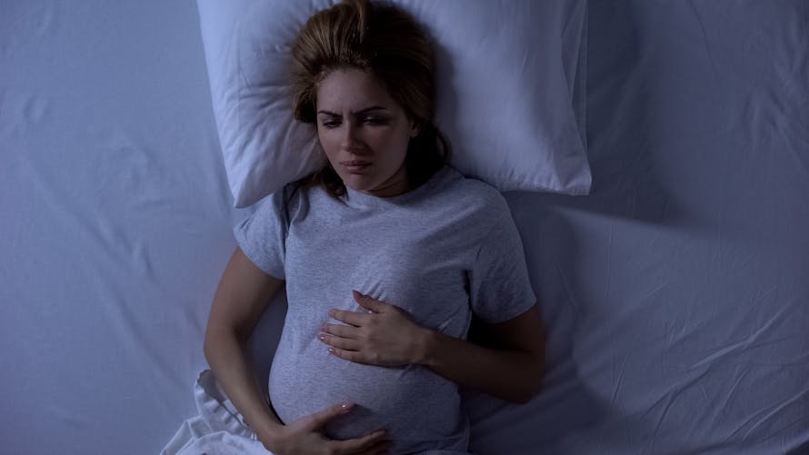 femme enceinte la nuit dans son lit