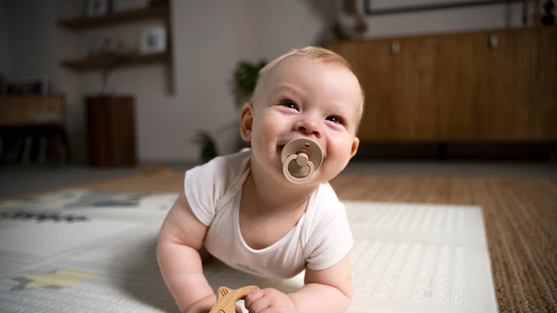 bébé avec tétine sur un tapis