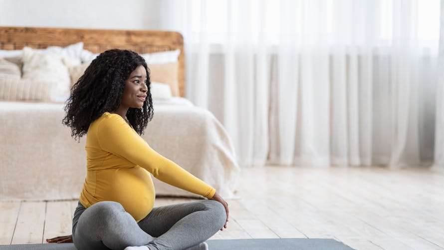 Une femme en fin de grossesse fait du yoga.