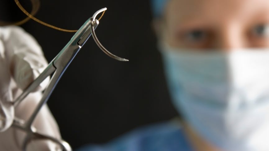 Un chirurgien s'apprête à réaliser des points de suture