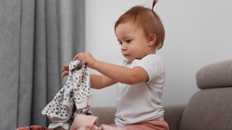 adorable bébé manipulant des vêtements