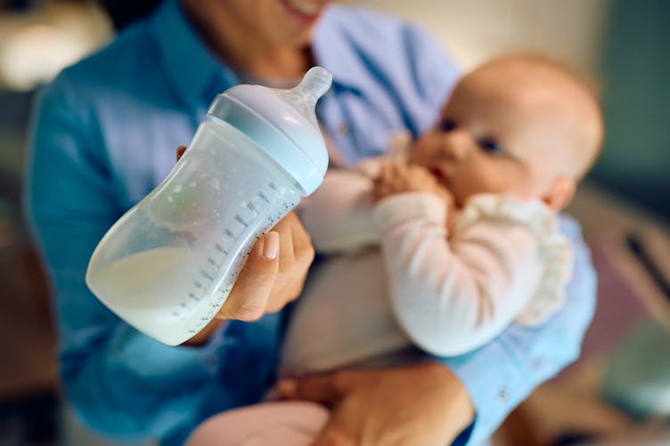 Une maman donne un biberon de lait à son bébé : des larves retrouvées dans du lait infantile