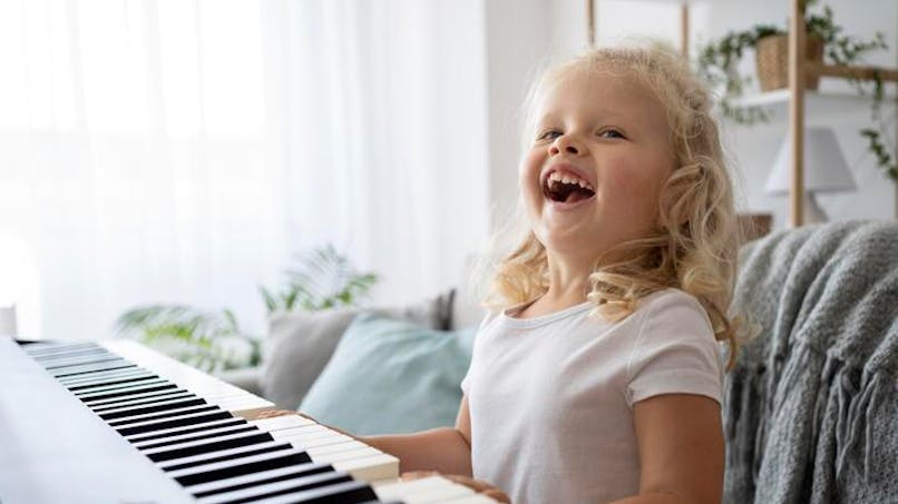 petite fille souriante au piano