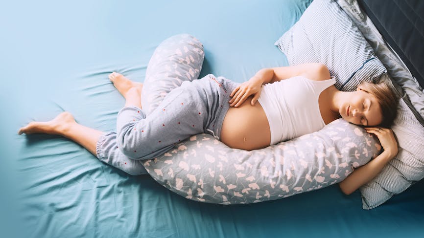 Femme dormant avec son coussin de grossesse