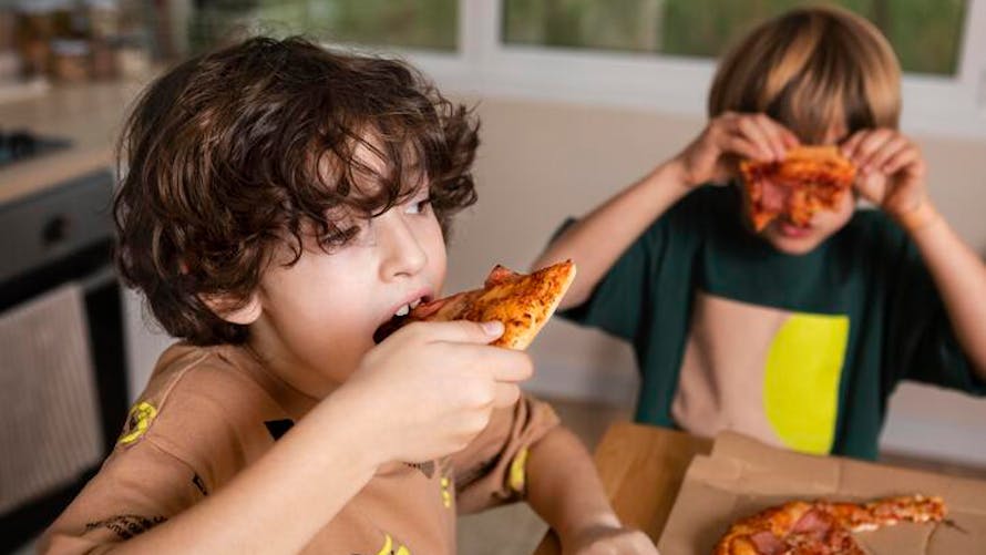 garçons mangeant une pizza