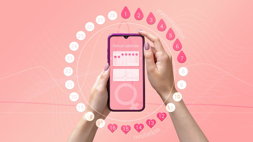 Application mobile de suivi du cycle menstruel sur l’écran du smartphone entre les mains d’une femme.