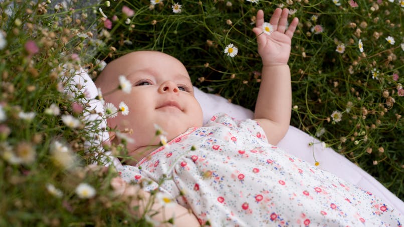 bébé fille dans l'herbe fleurie