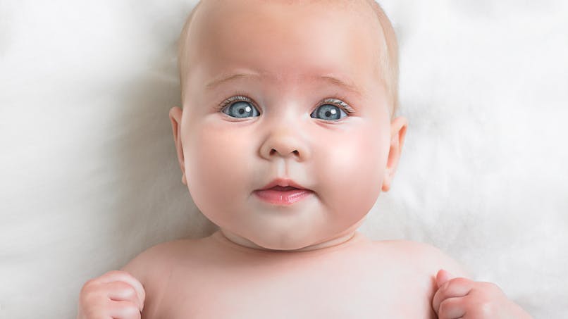 bébé yeux grands ouverts, poings serrés