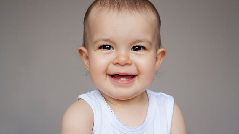 bébé qui sourit avec deux inscisives