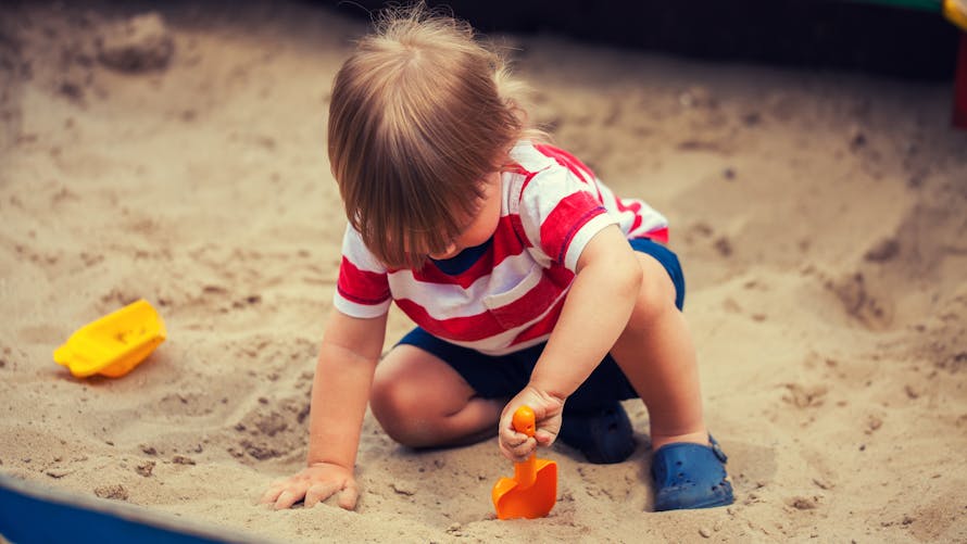 enfant joue dans bac à sable