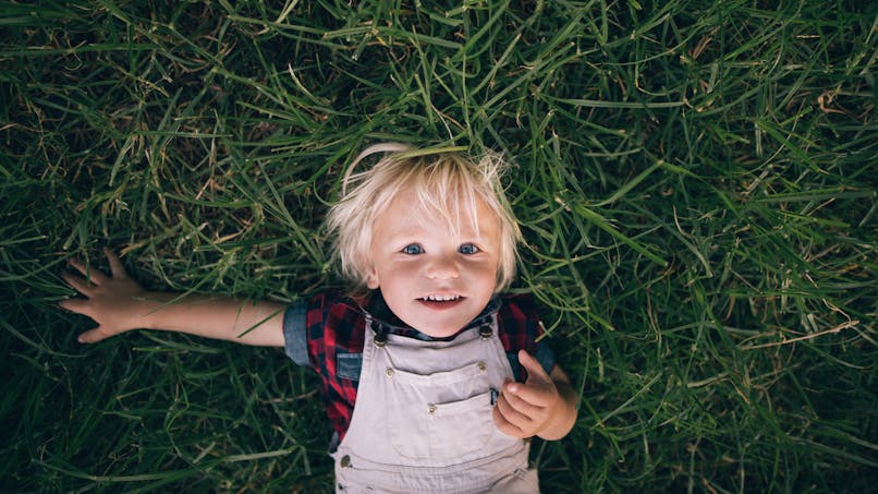 Enfant sur le dos dans l'herbe