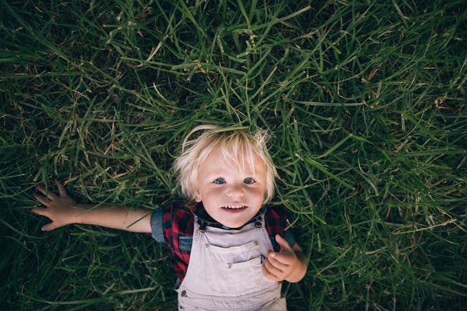 Enfant sur le dos dans l'herbe