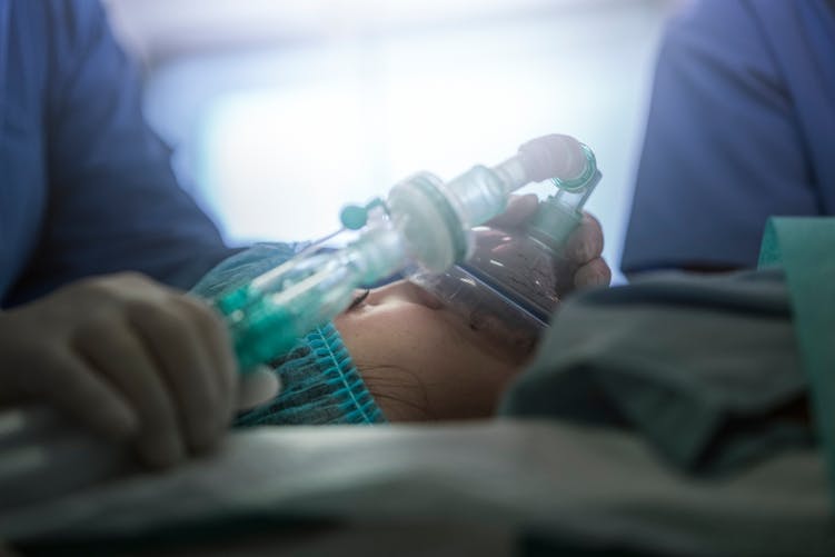Une enfant avec un masque à oxygène à l'hôpital