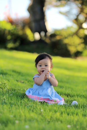 bébé fille indonésienne assise dans l'herbe