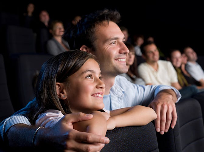 Père et fille partagent un moment ensemble au cinéma