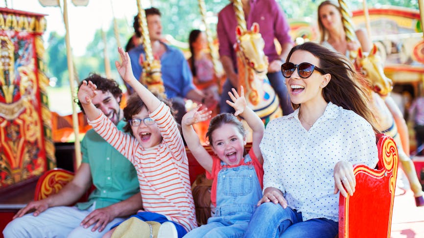 Famille sur un carroussel dans un parc d'attraction