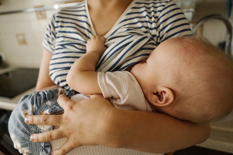 Un bébé tête le sein de sa maman