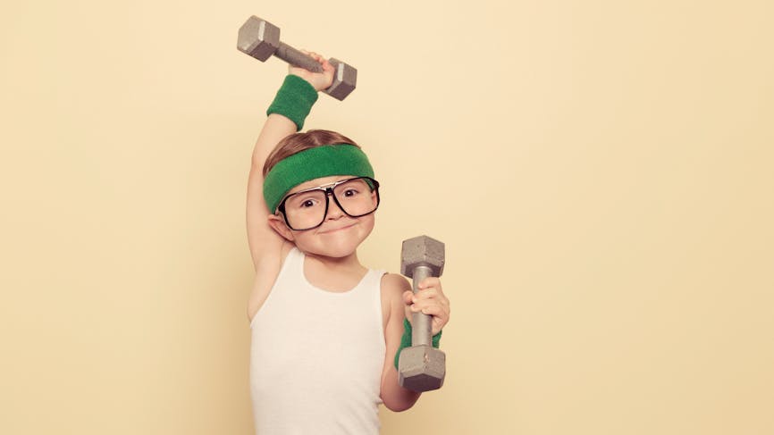 Un enfant porte des altères