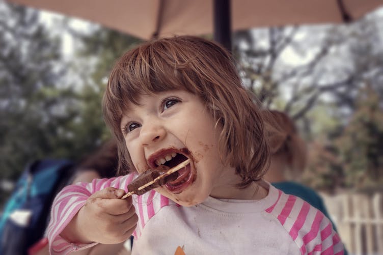 Petite fille qui mange du chocolat 