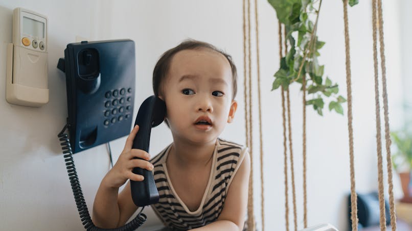 enfant indonésien au téléphone