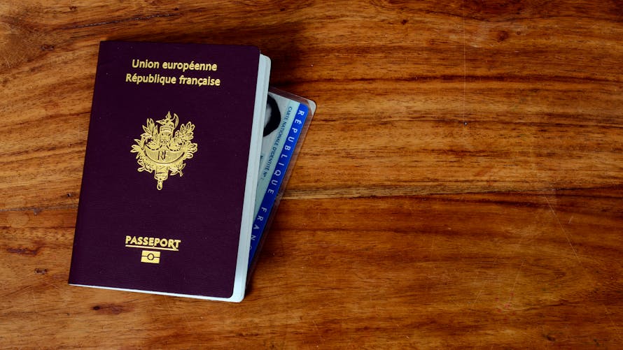 Un passeport et une carte nationale d'identité française posée sur une table