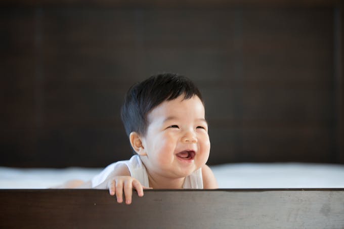 bébé asiatique qui rit dans son parc