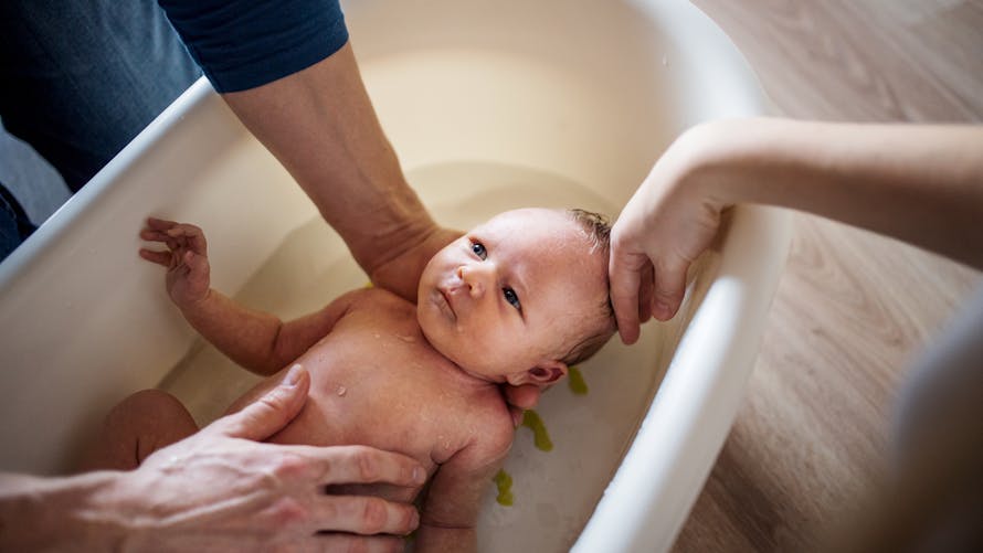 Un bébé prend un bain.