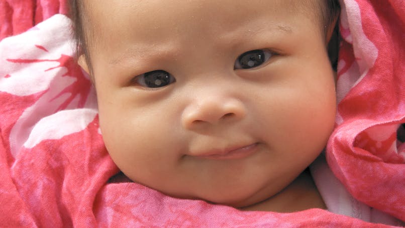 bébé fille hawaïenne dans couverture rose vif