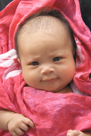 bébé fille hawaïenne dans couverture rose vif