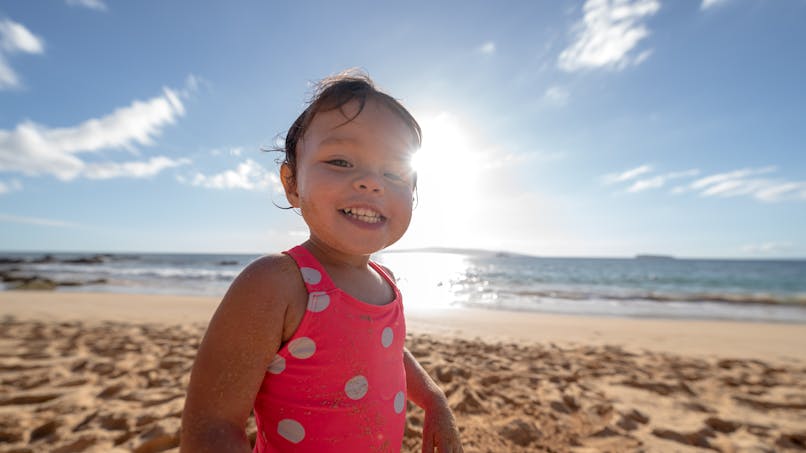 petite fille hawaïenne sur le plage en maillot de bain