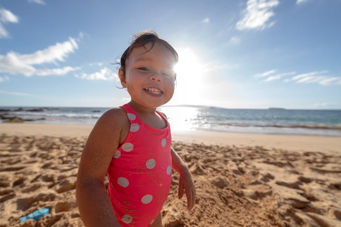 petite fille hawaïenne sur le plage en maillot de bain