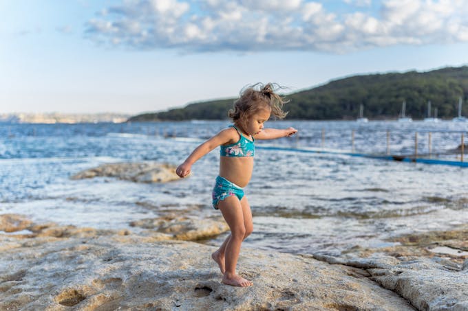 petite fille sur la plage en maillot de bain bleu