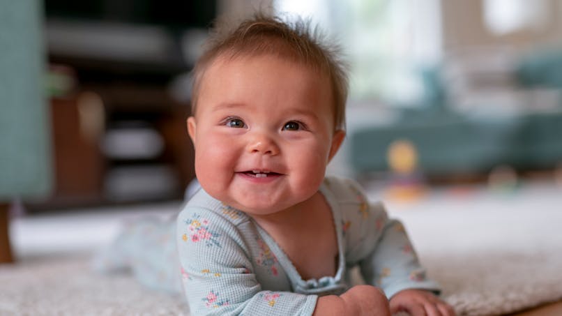 bébé fille sur un tapis a plat ventre
