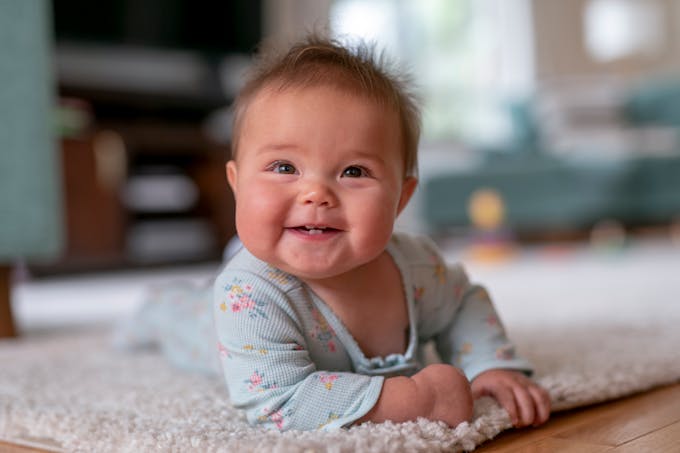 bébé fille sur un tapis a plat ventre
