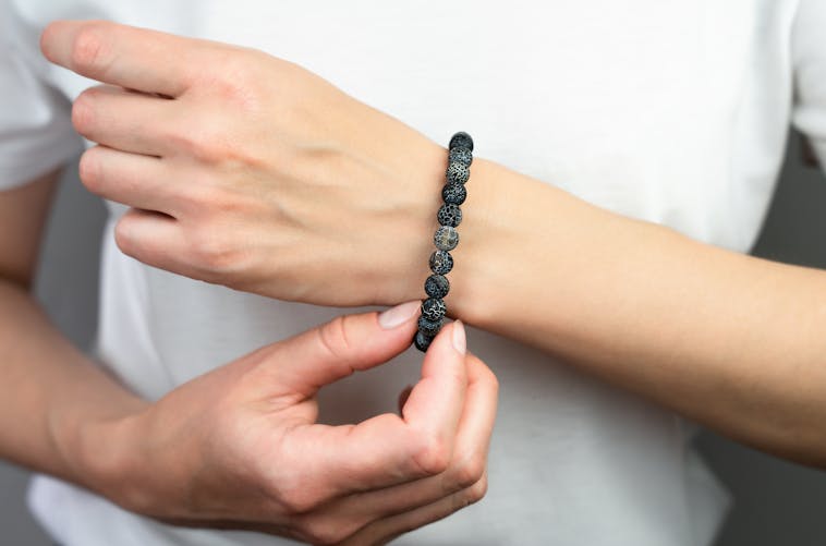 Femme qui porte un bracelet en pierres 