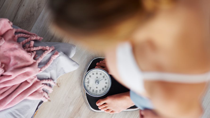 Alimentation et régime : une femme enceinte se pèse pendant sa grossesse.
