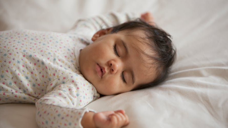 Un bébé aux cheveux bruns dort