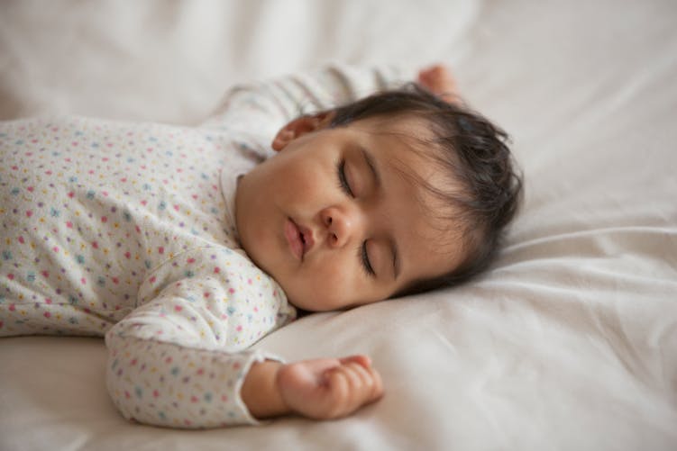 Un bébé aux cheveux bruns dort