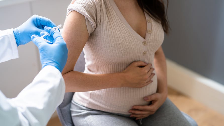 Une femme enceinte se fait vacciner. 